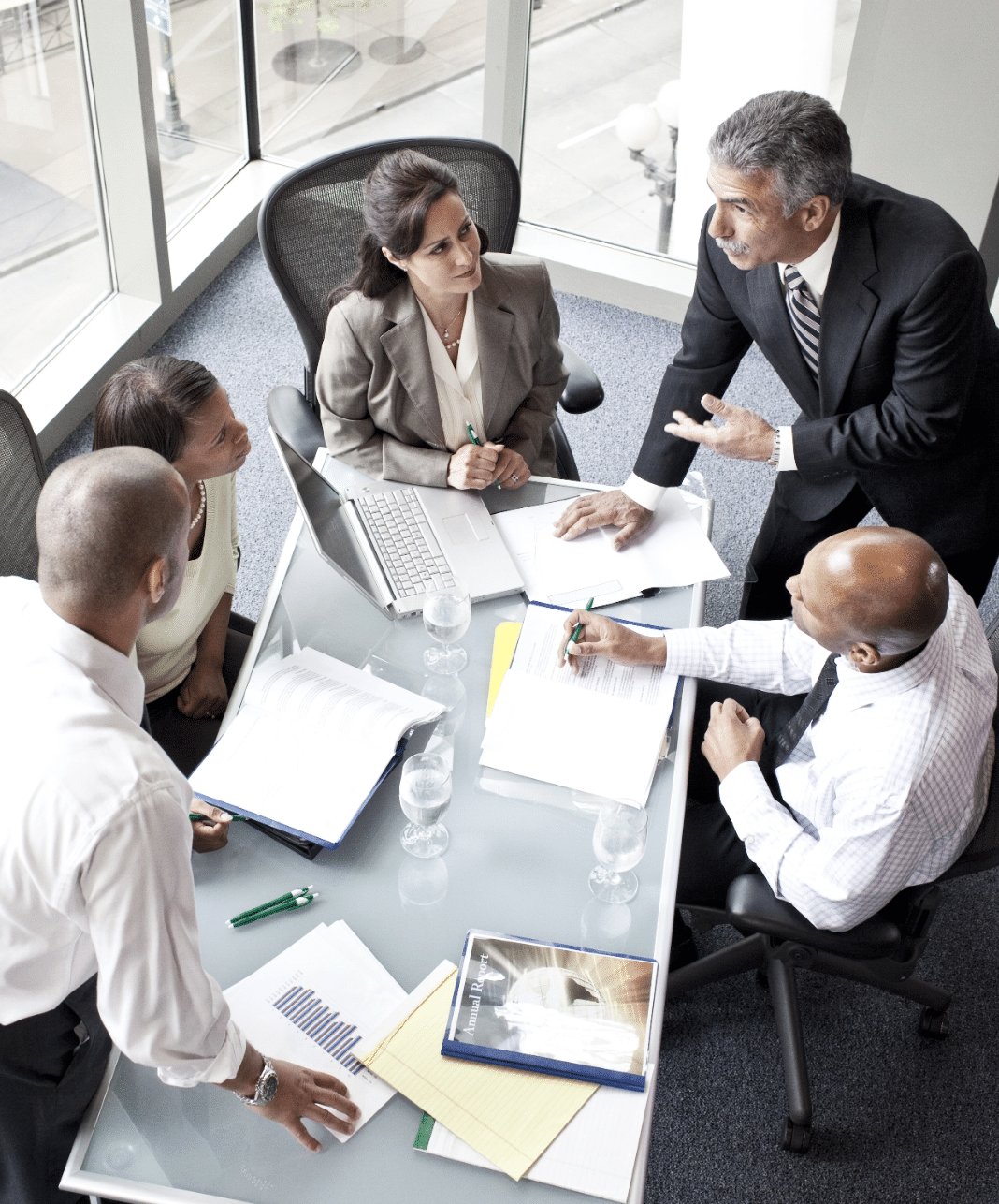 Male and female business people sit around a conference table during a planning session.